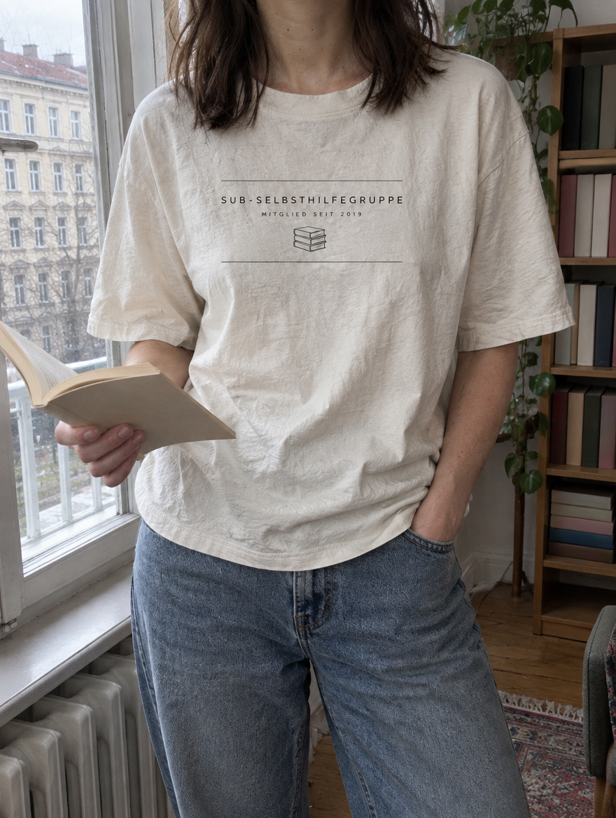 Nahaufnahme des Shirt-Drucks SuB-Selbsthilfegruppe – Mitglied seit 2019 am Fenster