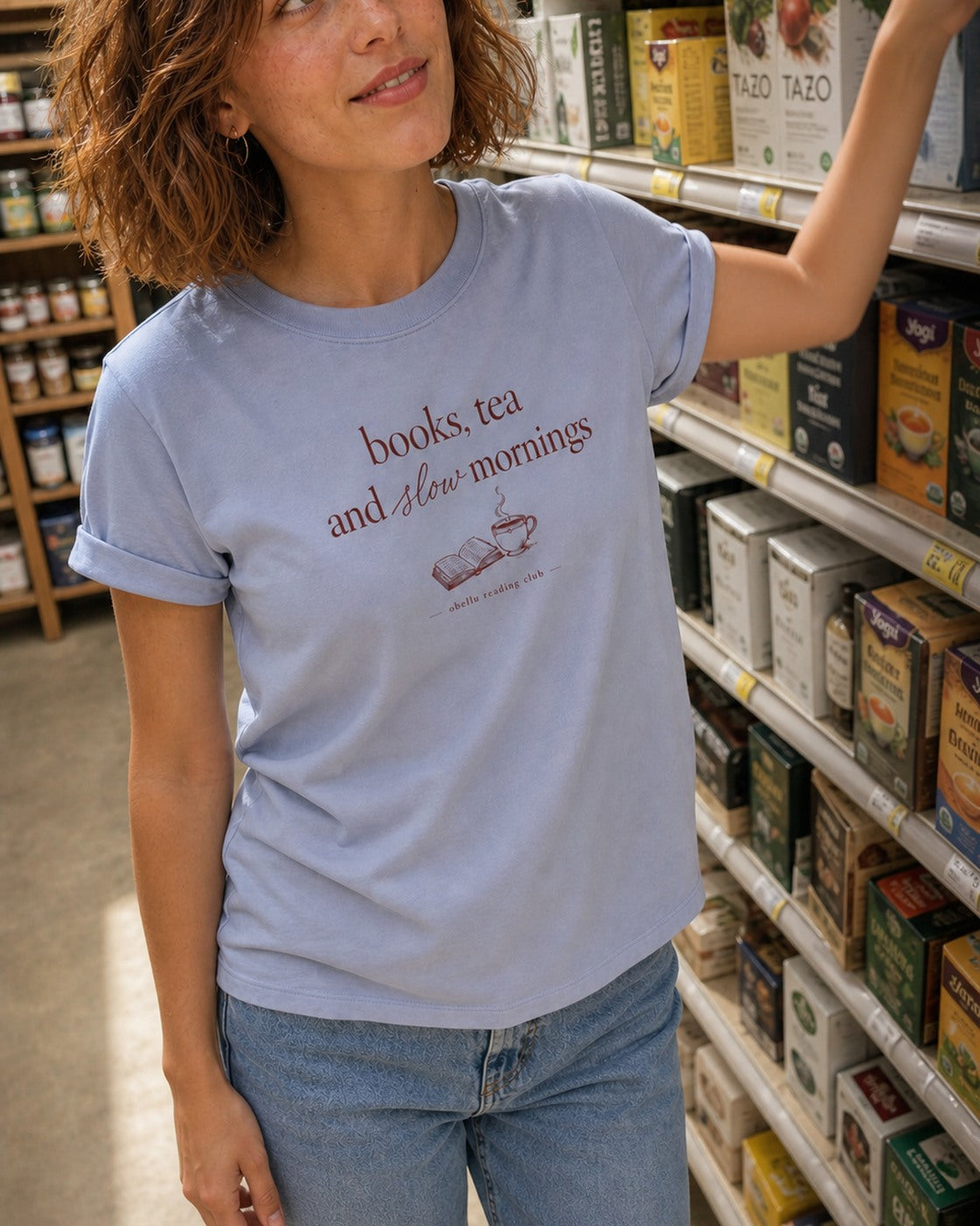 Books, Tea & Slow Mornings – Rolled Sleeve T-Shirt in Serene Blue – authentisches iPhone-Lifestylebild